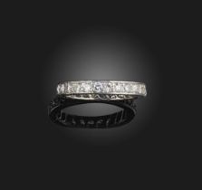 A diamond eternity ring, set with a continuous band of brilliant-cut diamonds, to an engraved