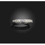 A diamond eternity ring, set with a continuous band of brilliant-cut diamonds, to an engraved