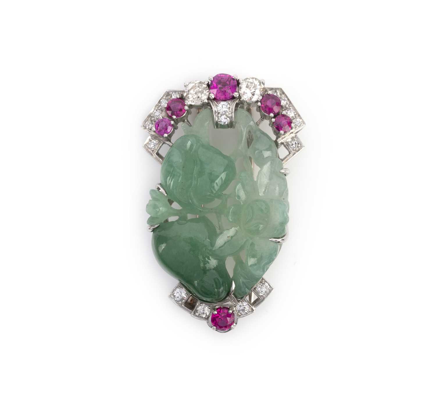 A jadeite, ruby and diamond brooch, mid 20th century, set with a section of jadeite carved with