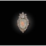 An opal and diamond ring, designed as a flaming heart motif, set with a pear-shaped cabochon opal