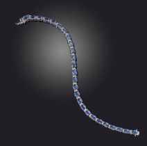 A sapphire and diamond line bracelet, designed as a line of oval sapphires totalling 11.29 carats,