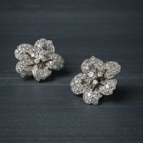 Cartier, a pair of diamond earrings, 1950s, each designed as a five-petalled flower, set with