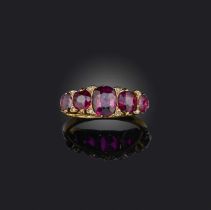 A late 19th century ruby five stone ring, set with graduated cushion-shaped rubies and diamond