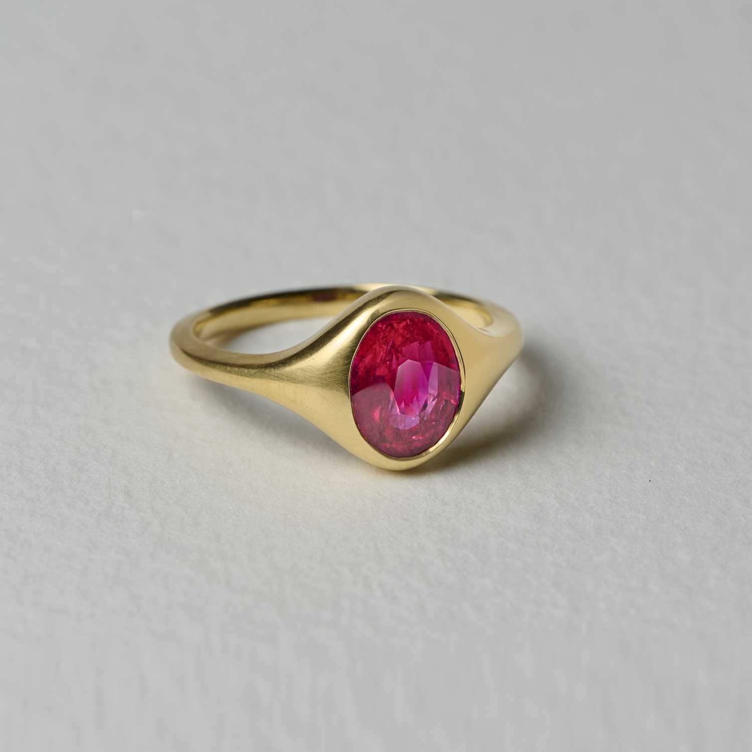 A ruby single-stone ring, rubover-set with an oval ruby weighing 2.09 carats, to a tapering gold