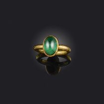 An emerald solitaire ring, the sugarloaf emerald in rubover setting on a polished 18ct yellow gold