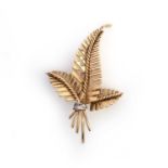 Garrard, an 18ct gold fern leaf brooch, of stylised design tied with a diamond-set ribbon, London