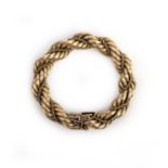 A gold bracelet, Italy, mid 20th century, of rope twist design, composed of engraved gold links