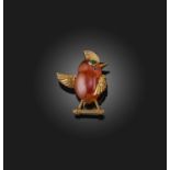 Cartier, a carnelian and emerald brooch, 1950s, designed as a bird in carved carnelian, its eye