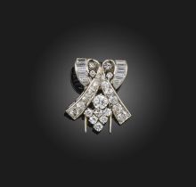 An Art Deco diamond clip brooch, 1930s, of scrolled design, set with circular-cut and baguette
