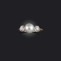 A natural pearl and diamond three-stone ring, set with a central button-shaped white pearl