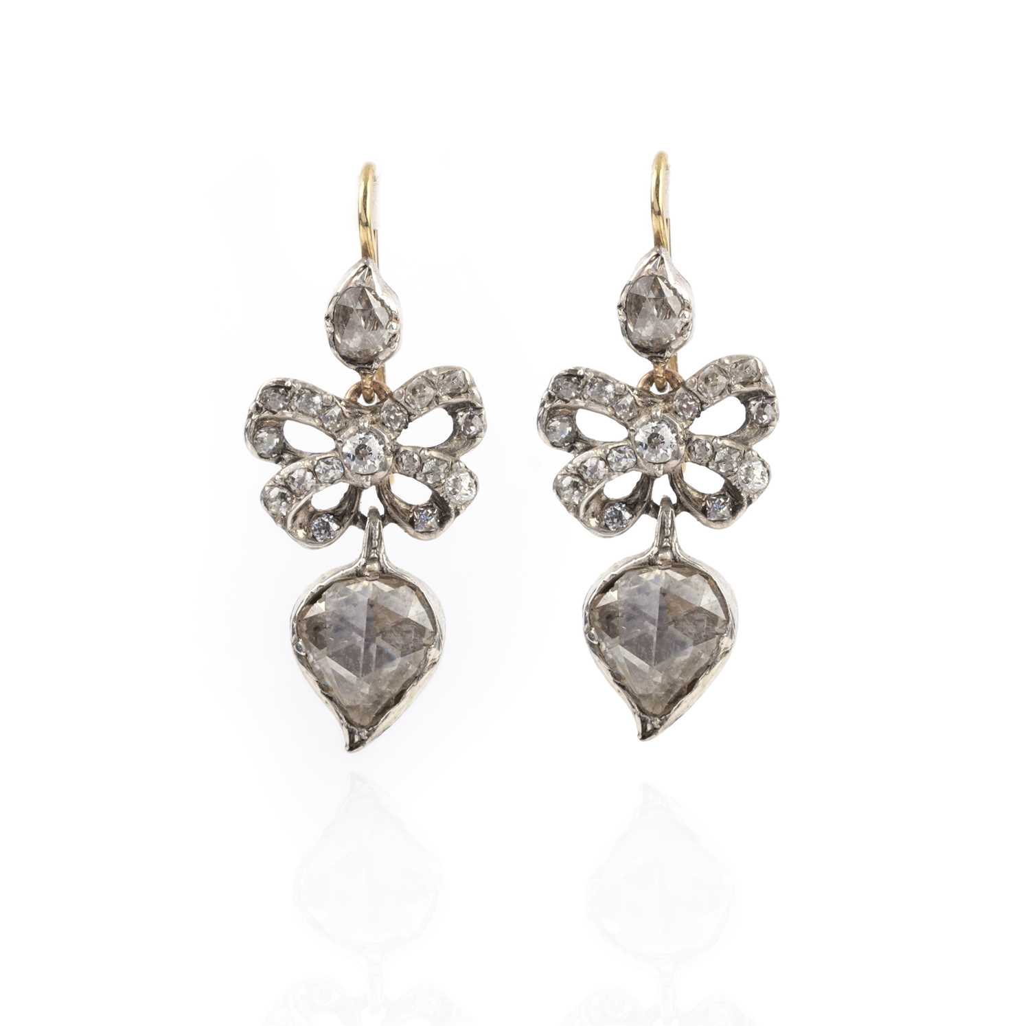 A pair of diamond drop earrings, set with rose-cut diamonds suspending diamond-set bows and a larger