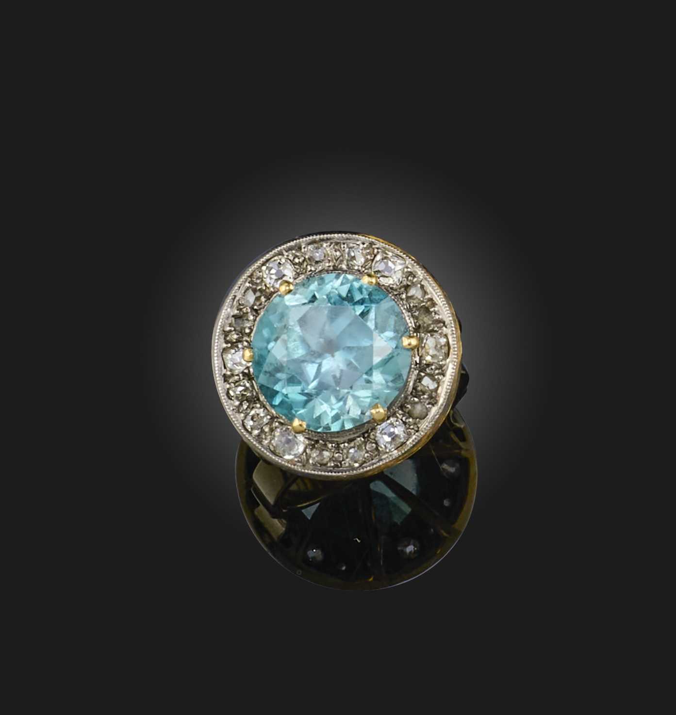 A blue zircon and diamond ring, of cluster design, set with a circular-cut blue zircon within a