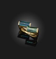 A tourmaline ring, of abstract design, set with two step-cut tourmalines in polished yellow gold