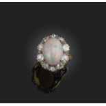 An opal and diamond ring, of cluster design, set with a cabochon opal within a border of circular-