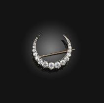 A Victorian diamond brooch, late 19th century, designed as a crescent moon, set with circular-cut