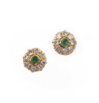 A pair of emerald and diamond stud earrings, each of cluster design, set with a circular-cut emerald