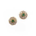 A pair of emerald and diamond stud earrings, each of cluster design, set with a circular-cut emerald