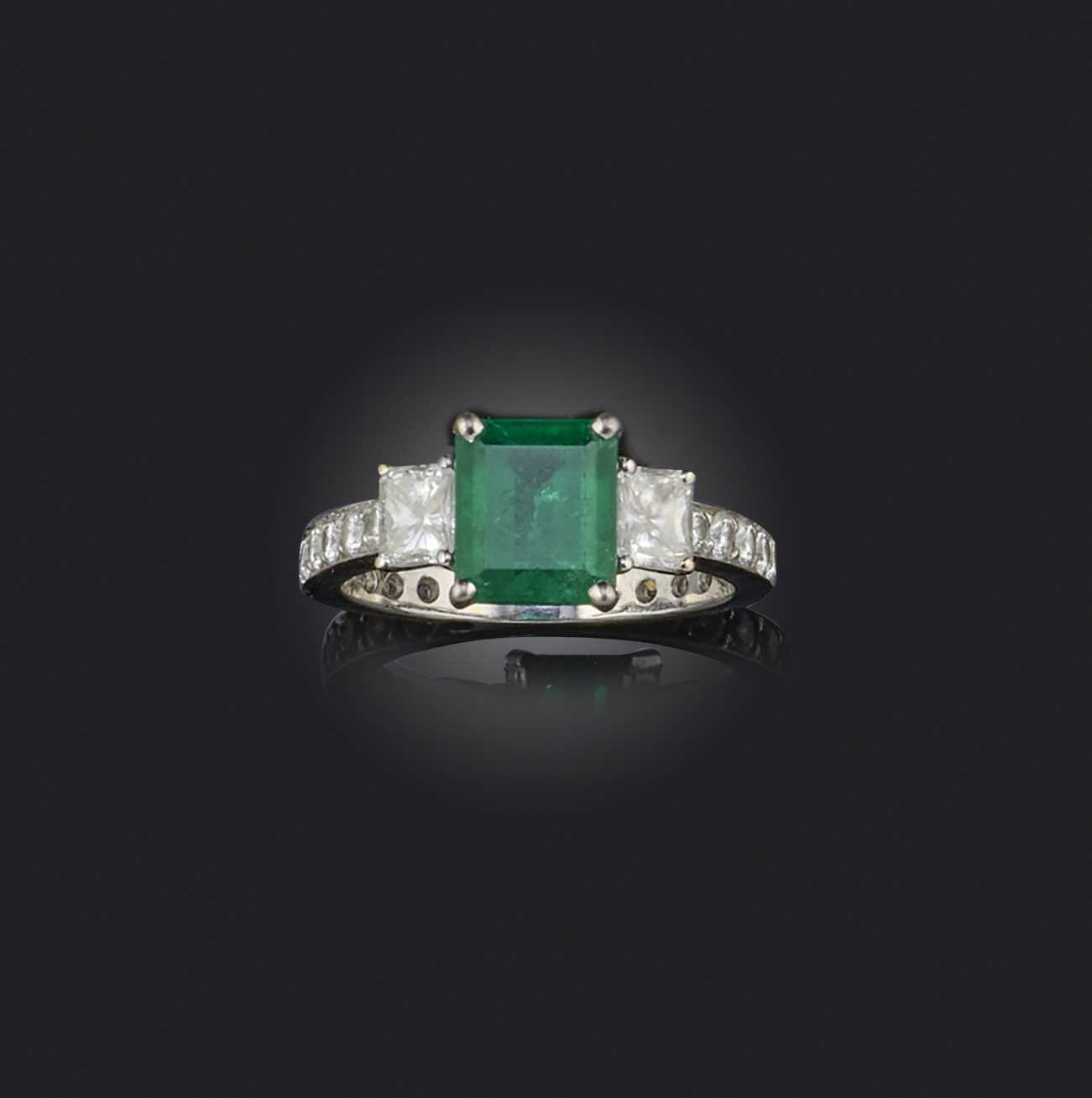 An emerald and diamond ring, claw-set with a step-cut emerald weighing approximately 1.60 carats,