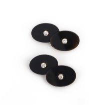 A pair of onyx, gold and diamond cufflinks, circa 1978, each end composed of an oval black onyx