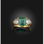 An emerald and diamond ring, early 20th century, set with a step-cut emerald, between shoulders