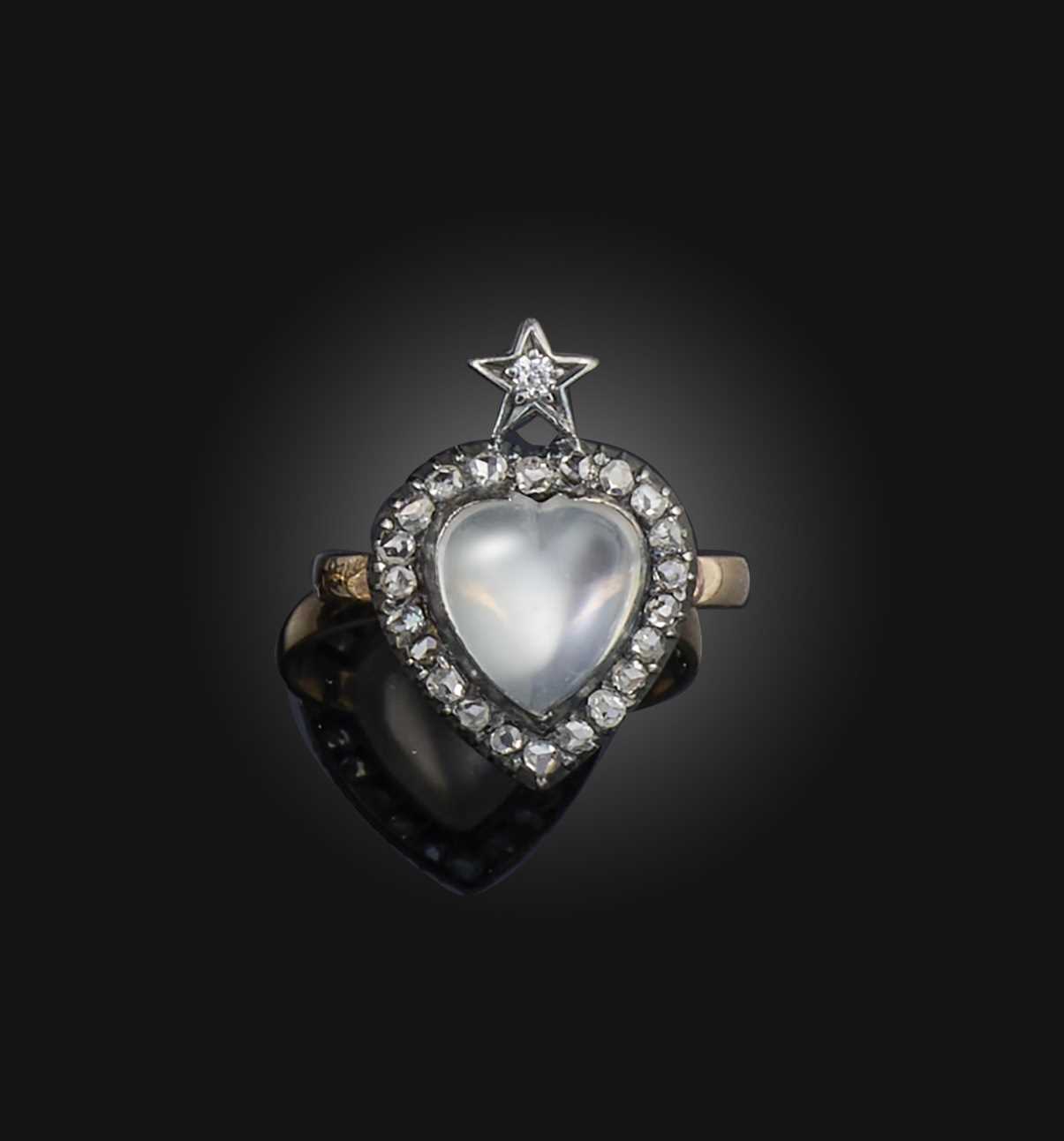 A moonstone and diamond ring, designed as a heart surmounted by a star, set with a polished heart-