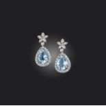 A pair of aquamarine and diamond earrings, each of drop design, composed of a floral surmount