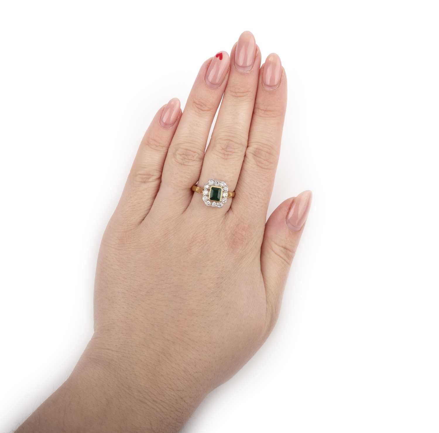 An emerald and diamond ring, of cluster design, set with a step-cut emerald within a border of - Image 2 of 2