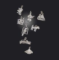 A collection of eight diamond charm pendants, comprising: a figure playing a lute; a house; a car; a