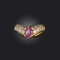 A star ruby and diamond ring, of wishbone design, set with a cabochon star ruby, to a band pavé-