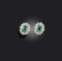 A pair of emerald and diamond earrings, of cluster design, set with step-cut emeralds totalling 1.10