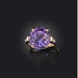 An amethyst and diamond ring, claw-set with a circular-cut amethyst, to shoulders set with