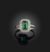 An emerald and diamond ring early 20th century, set with a step-cut emerald weighing approximately