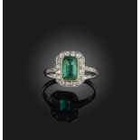 An emerald and diamond ring early 20th century, set with a step-cut emerald weighing approximately