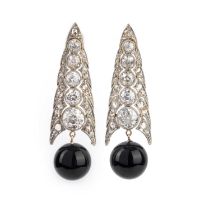 A pair of onyx and diamond earrings, each composed of a tapering surmount set with graduated