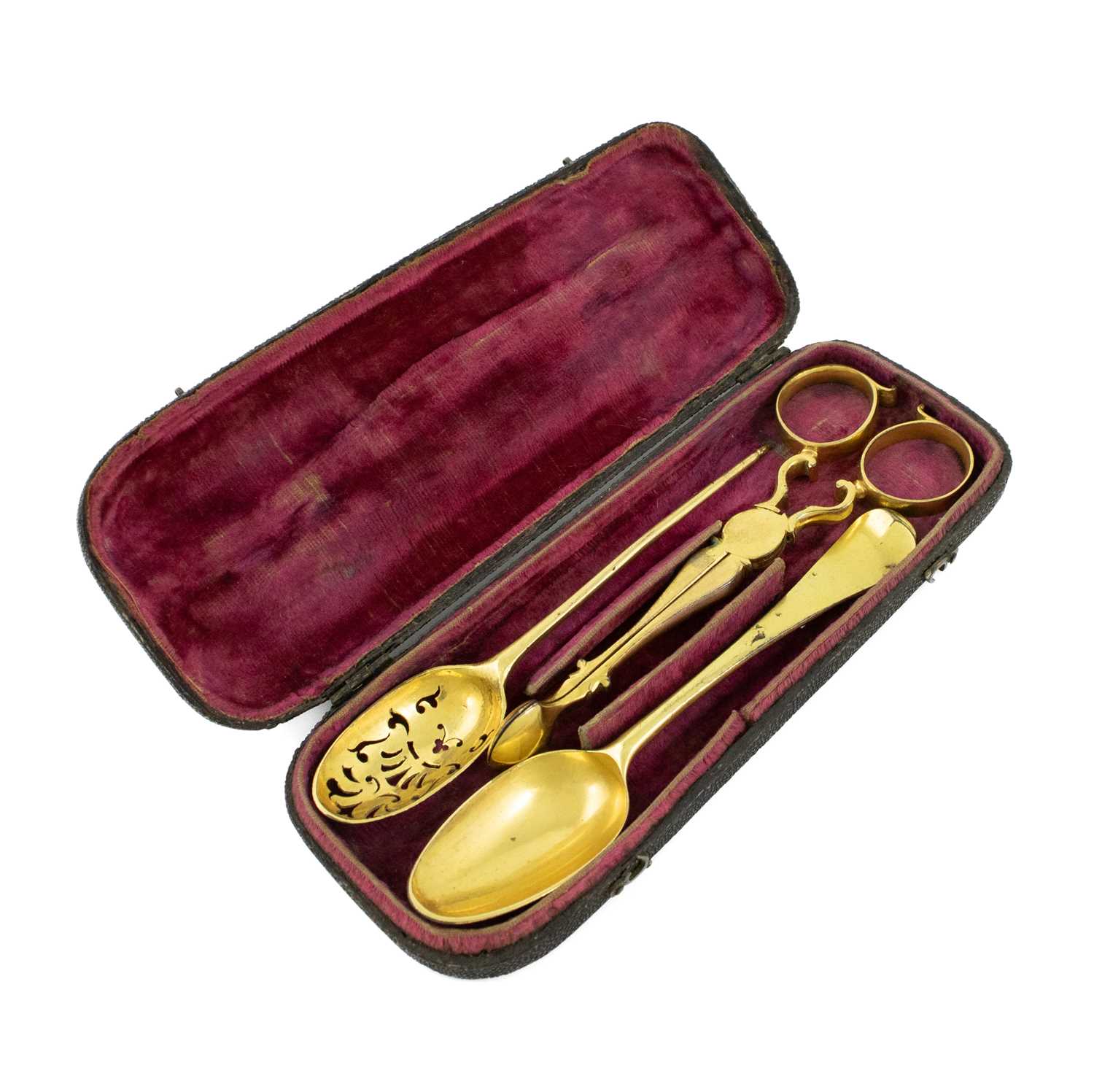 An 18th century gilt copper pair of sugar nips, teaspoon and mote spoon, the spoon with partial