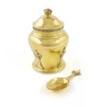 A silver-gilt tea caddy and spoon, by Goldsmiths & Silversmiths Co Ltd, London 1936, baluster