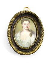 An 18th century English School enamelled portrait miniature, unsigned, the young lady in a white