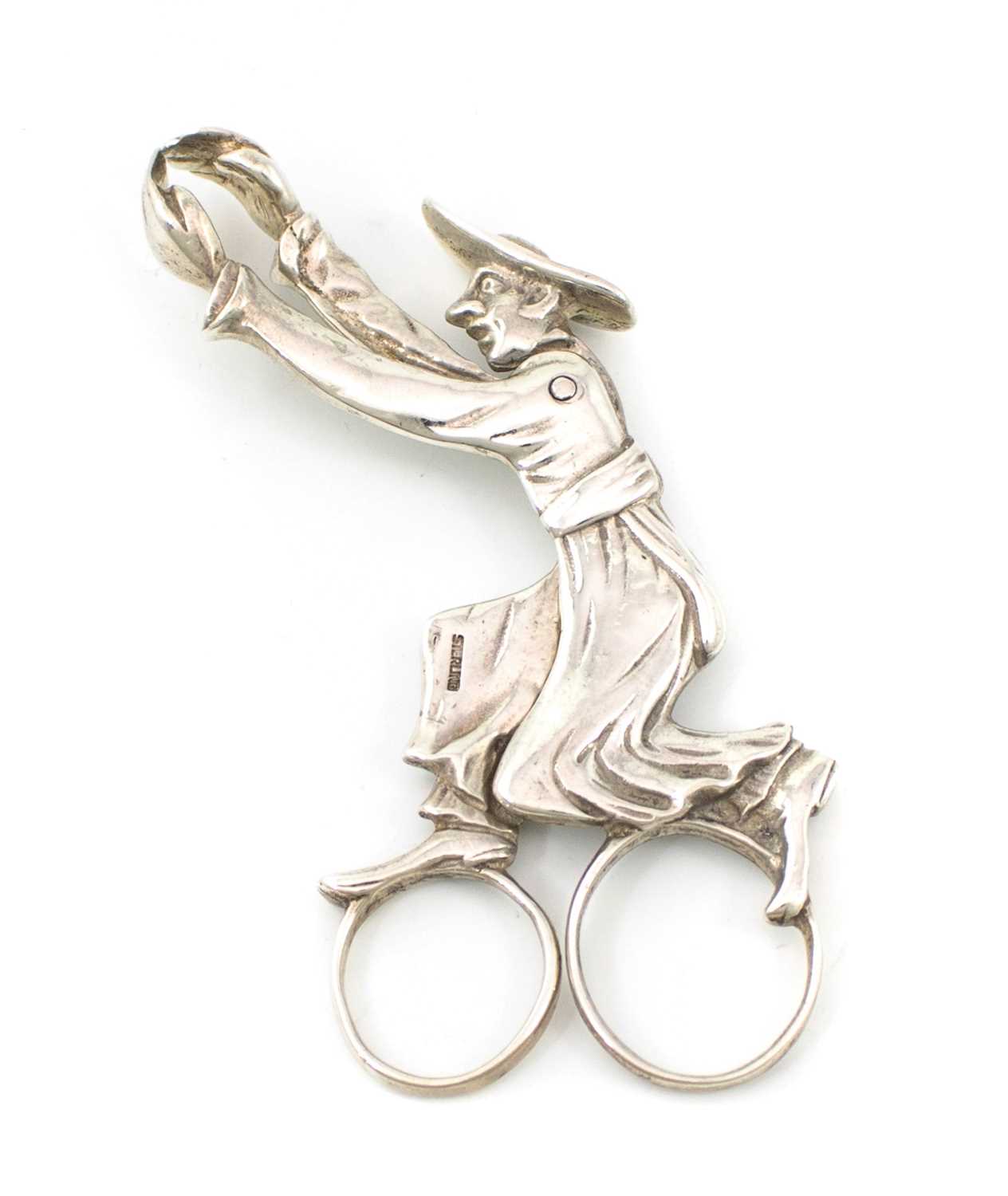 A pair of novelty silver tongs, marked Sterling, modelled as a running priest with out-stretched