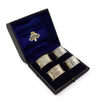 A set of four Edwardian silver napkin rings, by Reid and Sons, London 1906, circular form,