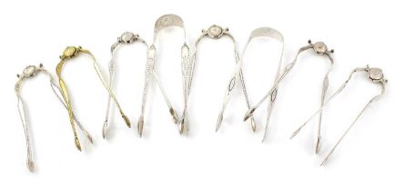A collection of eight pairs of George III silver sugar tongs, various dates and makers, including: