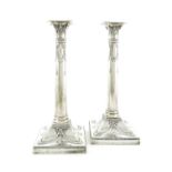 A pair of silver candlesticks, by Mappin & Webb Ltd, London 1913, the columns with ribbon-tied