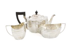 A three-piece silver tea set, by The Barker Brothers, Chester 1911, panelled oval form, scroll