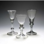 Two English balustroid wine glasses, c.1740, one with a bell bowl, the other with a funnel bowl,