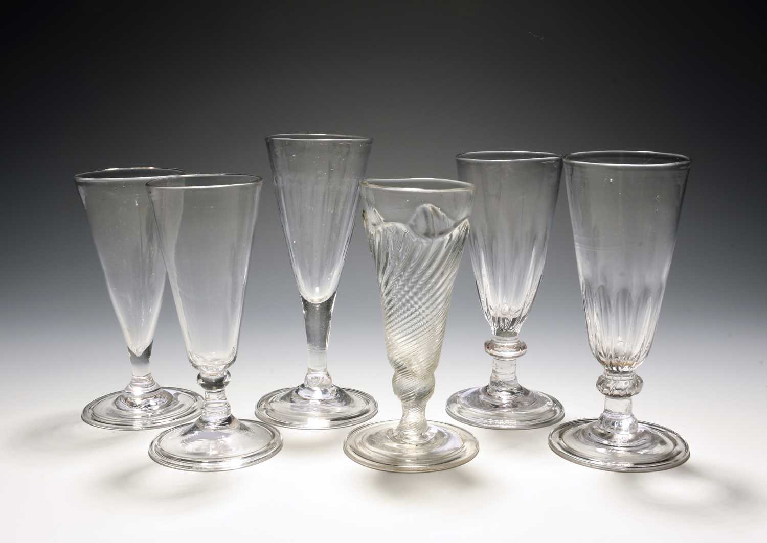 Six dwarf ale glasses or flutes, c.1730-60, one with flammiform moulding, two with vertical