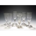 Six dwarf ale glasses or flutes, c.1730-60, one with flammiform moulding, two with vertical