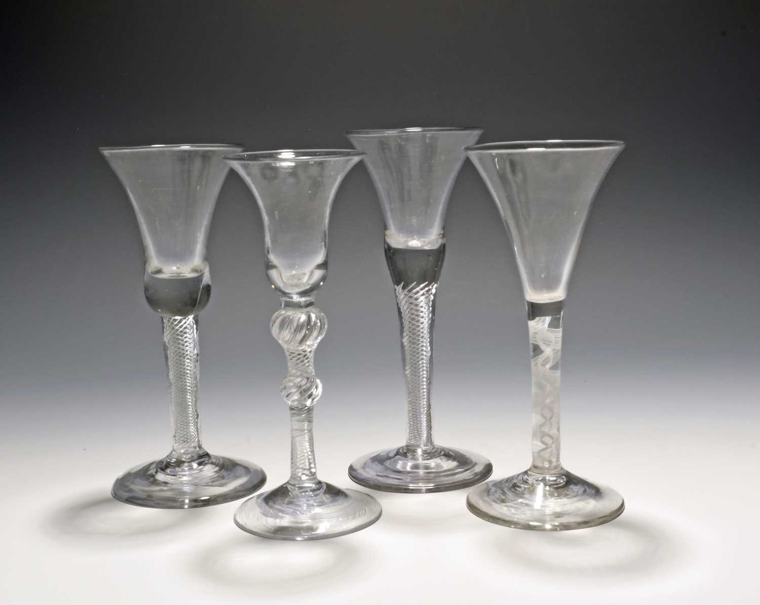 Four wine glasses, mid 18th century, three with bell bowls raised on airtwist stems, the last with a