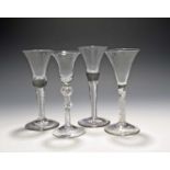 Four wine glasses, mid 18th century, three with bell bowls raised on airtwist stems, the last with a
