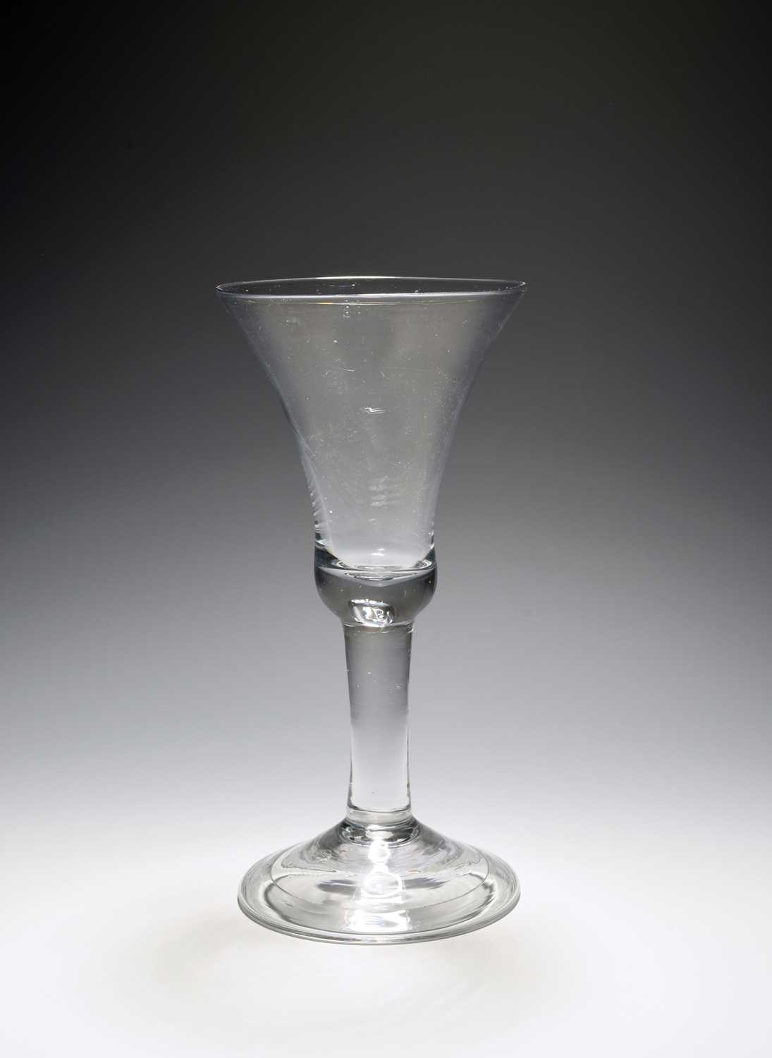 A large toasting glass or goblet, c.1740, the tall bell bowl with a solid base, raised on a plain