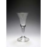 A large toasting glass or goblet, c.1740, the tall bell bowl with a solid base, raised on a plain