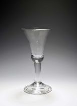 A large toasting glass or goblet, c.1740, the tall bell bowl with a solid base, raised on a plain